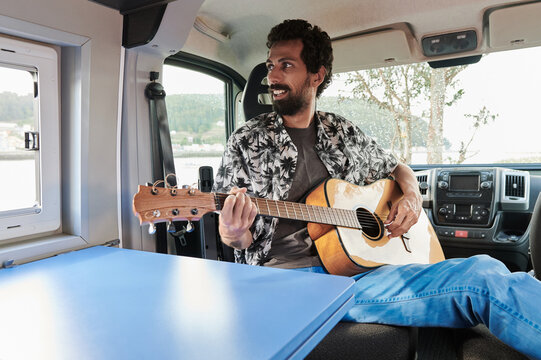 Man playing guitar in van
