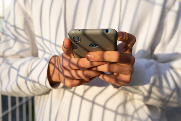 Anonymous man browsing smartphone and looking away