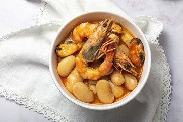 Bowl with typical beans stew with prawns shrimps and mussels