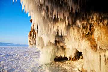 An ice cave near the frozen Lake Baikal. Icicles on the rocks. Winter trip.