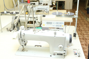 Shop for tailoring. A woman creates clothes on a sewing machine. Fashion industry for people. Stylish fashionista woman creating new cloth design collection. Tailor and sewing. 