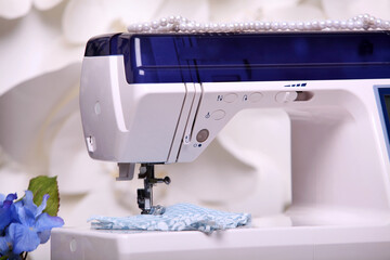 Composition from a sewing machine. Mannequin, flowers on a retro table and threads. Sewing supplies and composition with a sewing machine in the interior. With the letter M. for the fashion magazines