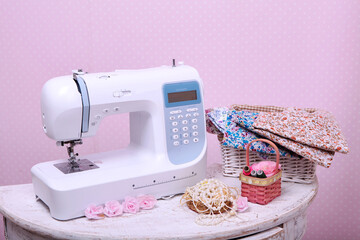 Composition from a sewing machine. Mannequin, flowers on a retro table and threads. Sewing supplies and composition with a sewing machine in the interior. With the letter M. for the fashion magazines