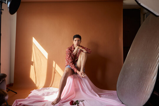 Gay on crumpled fabric in photo studio