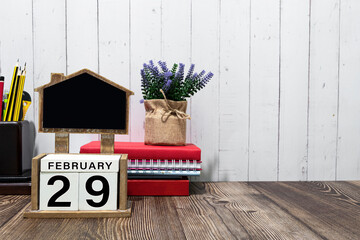 February 29 calendar date text on wooden block with stationeries on wooden desk.
