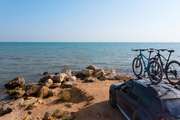 Fototapeta na wymiar Two bikes on the roof rack of a car against a beautiful nature.