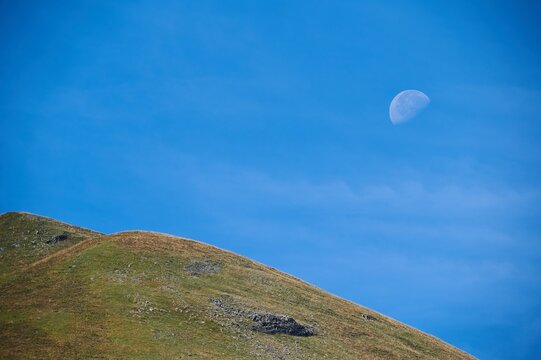 Grassy valley against blue sky