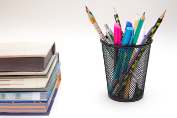 A group of school supplies and books on a wooden table on a white background