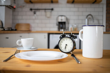 intermittent fasting concept alarm clock on kitchen table