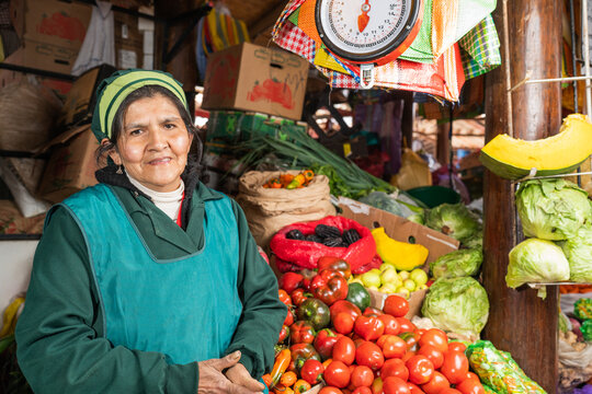 Peruvian seller in mask near tomatoes