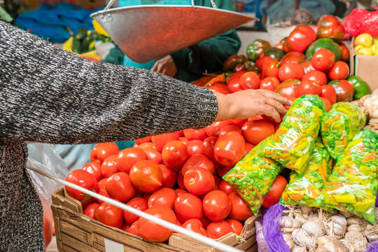 Unrecognizable buyer picking ripe tomatoes in store