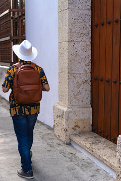 Back view of anonymous traveler in city