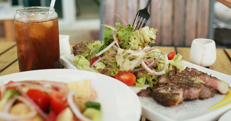 Fresh salad and grilled beef in outdoor cafe