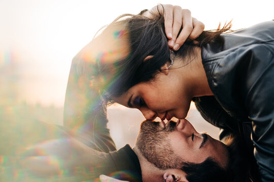 Ethnic couple kissing with closed eyes outdoors