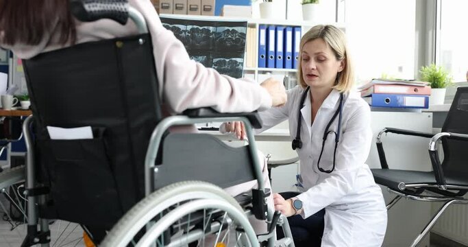 The doctor hits knees of a man in a wheelchair with hammer