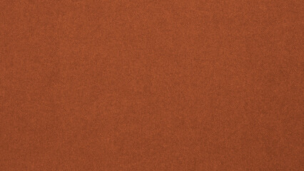 Dark orange colored paper texture. Bright brown tinted background or wallpaper. Textured surface, fibers and irregularities are visible. Top-down