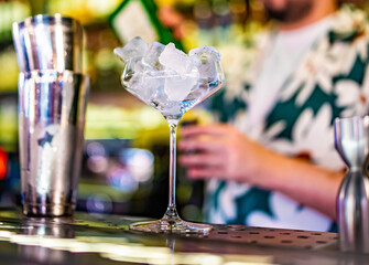 Ice cube in an empty glass on a bar counter in bar or pub