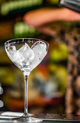 Ice cube in an empty glass on a bar counter in bar or pub