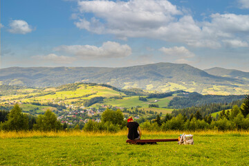 Fototapeta Młoda kobieta siedząca w górach patrząca na piękny krajobraz  obraz