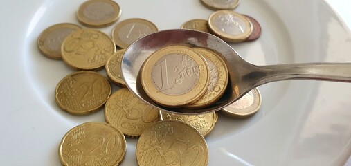 Euro coins on a white background. Money background. Euro currency in Europe. One euro, fifty cents, twenty cents and ten cents. Euro coins in a spoon.