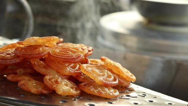 Fresh Cooked Hot Rasdar Jalebi Also Known As Jilapi, Jilebi, Jilipi, Zulbia, Jerry, Zalebi, Mushabak Mithai Made From Fermented Maida And Besan Dunked In Cheeni Ki Chasni Or Paag. Smoke In Background
