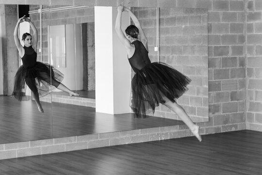 Young ballerina jumping at dance studio