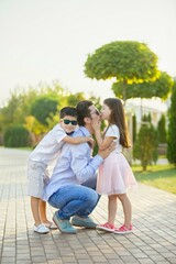 A father and his two children, a boy and a girl, are on a Park path.