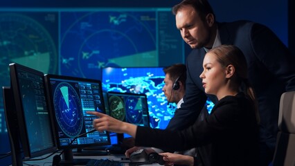 Workplace of the air traffic controllers in the control tower. Team of professional aircraft control officers works using radar, computer navigation and digital maps. Aviation concept.