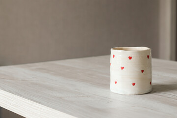 handmade ceramic cup with small hearts for coffee and tea. space for text