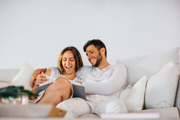 Young couple relaxing together on couch with book
