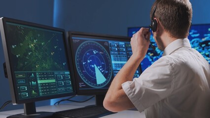 Workplace of the professional air traffic controller in the control tower. Caucasian aircraft control officer works using radar, computer navigation and digital maps. Aviation concept.