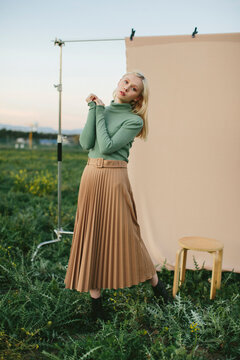 Alluring Young Woman Standing In Field Against Empty Hanged Canv