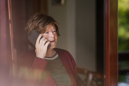 Senior woman making call at home