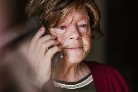 Senior woman making call at home
