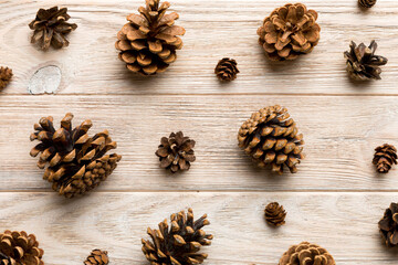 Fototapeta na wymiar pine cones on colored table. natural holiday background with pinecones grouped together. Flat lay. Winter concept