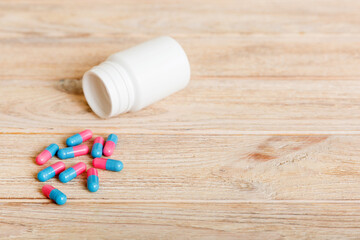 Fototapeta na wymiar plastic medicine bottle with capsules of pills on colored background. Online pharmacy. Painkiller medicine and antibiotic drug resistance concept. Pharmaceutical industry