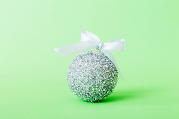 Christmas ball on colored background. decoration bauble with ribbon bow with copy space