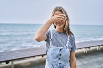 Young caucasian woman outdoors smiling and laughing with hand on face covering eyes for surprise....