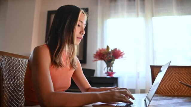 A video of a young asian girl studying at home.