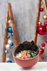 poke salad with tuna is a traditional dish of Hawaiian and Japanese cuisine. Christmas balls are visible in the background. vertical snapshot.