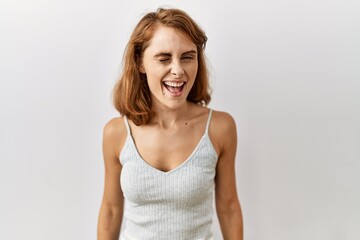 Fototapeta premium Beautiful caucasian woman standing over isolated background winking looking at the camera with sexy expression, cheerful and happy face.