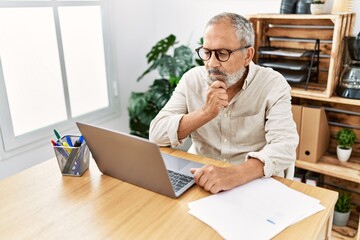 Senior grey-haired man stressed working at office