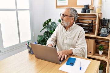 Senior grey-haired man smiling confident working at office