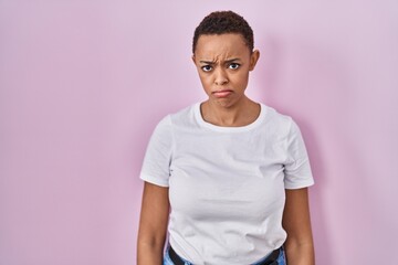Beautiful african american woman standing over pink background depressed and worry for distress, crying angry and afraid. sad expression.