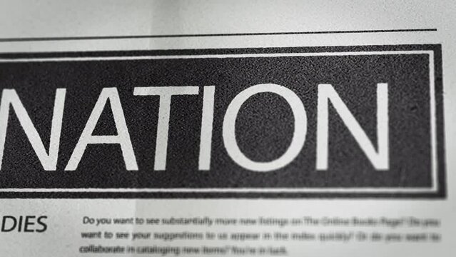 Footage of Assassination written newspaper close up shot to the text.