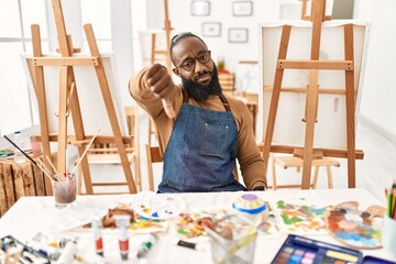 African american artist man at art studio looking unhappy and angry showing rejection and negative...