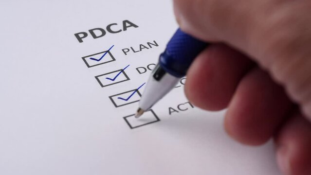 PDCA or PLAN, DO, CHECK, ACTION Business Management Concept. Businessman tick off or marking with blue on checklist, checkbox after completing task on white paper. Selective focus 4K resolution