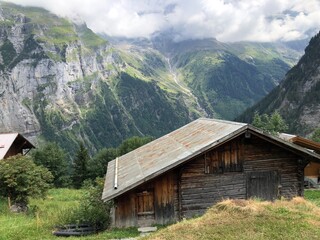 Fototapeta na wymiar A wooden house in mountains with nobody, Murren, Swiss Alps, Switzerland, summer 2022. An image of solitude in the mountains and a peaceful lifestyle. Swiss Alps scenery. Swiss countryside