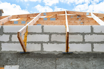 Roof trusses not covered with ceramic tiles on a single-family house under construction, visible roof elements and rafters.