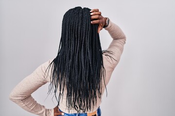African woman with braids standing over white background backwards thinking about doubt with hand on head - obrazy, fototapety, plakaty